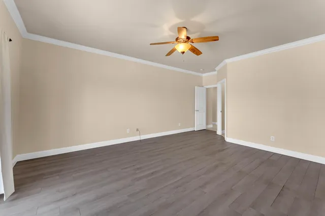 a view of a room with wooden floor and ceiling fan