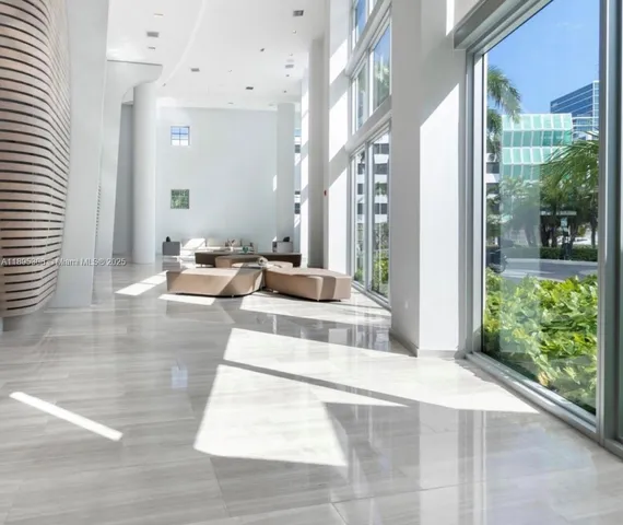 a lobby with furniture and floor to ceiling windows