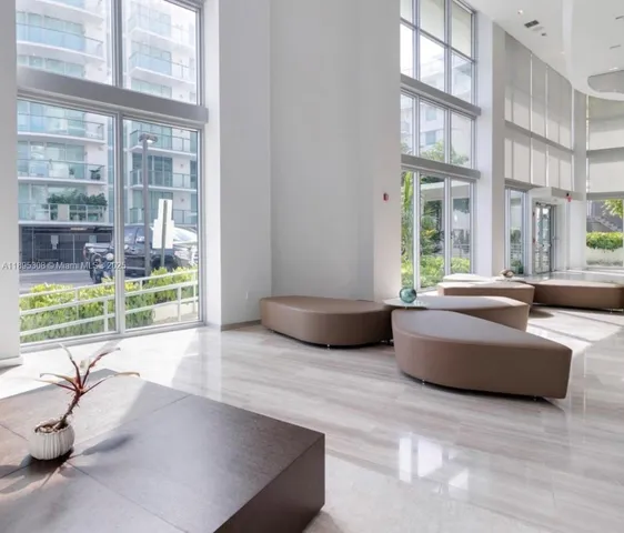 a living room with furniture and a floor to ceiling window