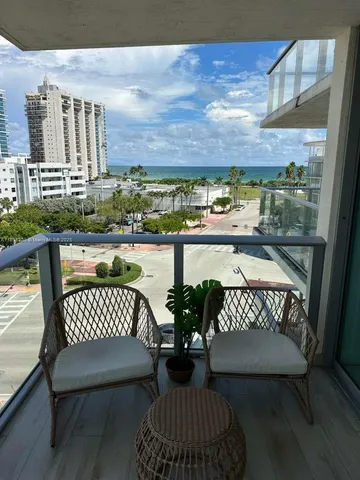 a view of a balcony with two chairs and a wooden floor