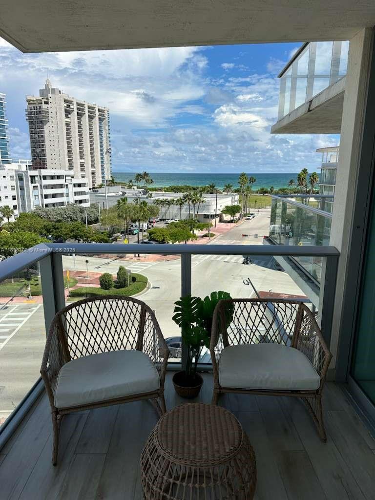 6620 Indian Creek Drive, Unit 616 Miami Beach, FL 33141 - Photo 5 of 19 a view of a balcony with two chairs and a wooden floor