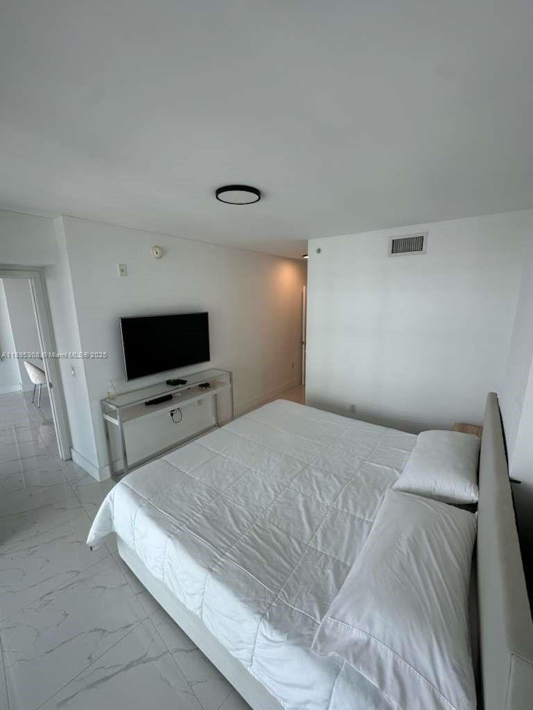 6620 Indian Creek Drive, Unit 616 Miami Beach, FL 33141 - Photo 7 of 19 a bedroom with a bed and a flat screen tv