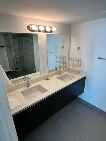 a bathroom with a double vanity sink and mirror