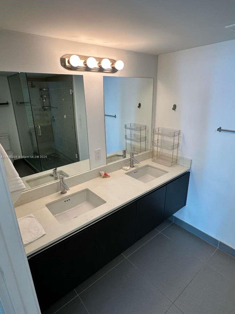 6620 Indian Creek Drive, Unit 616 Miami Beach, FL 33141 - Photo 8 of 19 a bathroom with a double vanity sink and mirror
