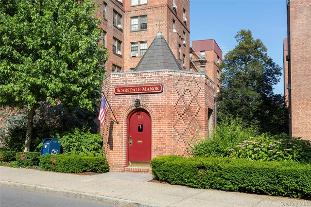 front view of a brick house with a yard