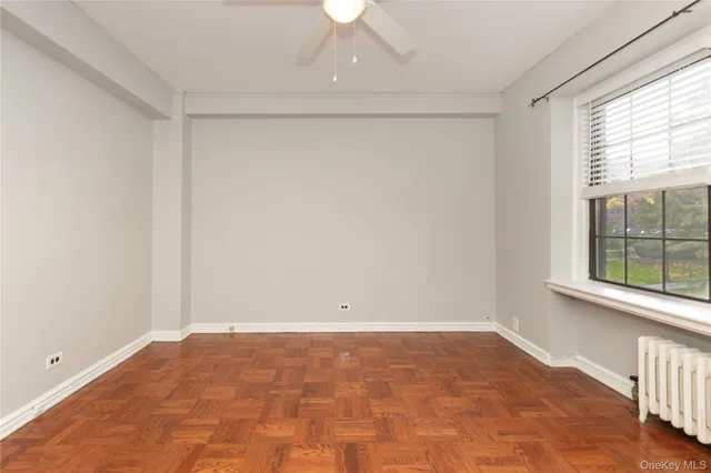 an empty room with a window and a ceiling fan