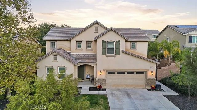 a view of a white house with a yard and large tree