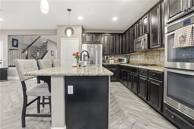 a kitchen with stainless steel appliances granite countertop a sink stove and cabinets