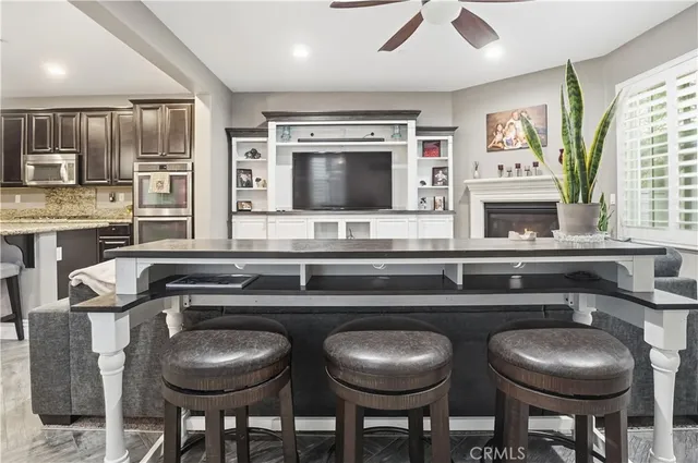 a kitchen with stainless steel appliances kitchen island granite countertop a refrigerator a stove microwave and island with wooden floor