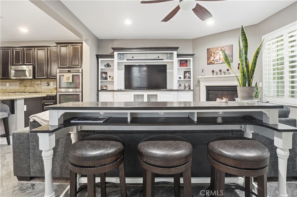 25654 Red Hawk Road Corona, CA 92883 - Photo 15 of 75 a kitchen with a table chairs stove and microwave