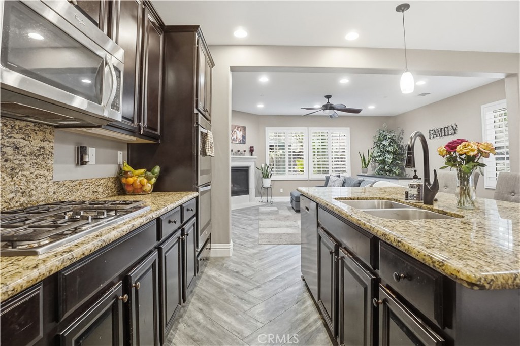25654 Red Hawk Road Corona, CA 92883 - Photo 16 of 75 a kitchen with stainless steel appliances granite countertop a sink a stove and a wooden cabinets