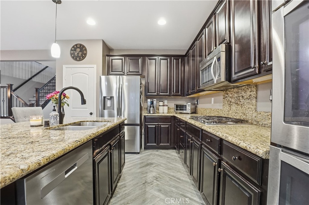 25654 Red Hawk Road Corona, CA 92883 - Photo 17 of 75 a kitchen with stainless steel appliances granite countertop a sink stove and cabinets