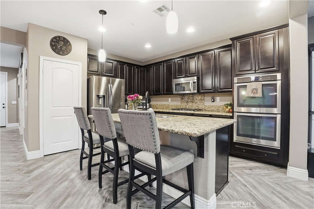25654 Red Hawk Road Corona, CA 92883 - Photo 10 of 75 a kitchen with kitchen island a counter space a sink appliances and cabinets