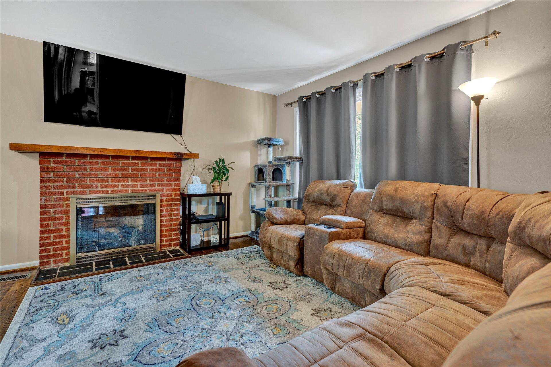 3382 Thomasson Mill Road Goodview, VA 24095 - Photo 5 of 20 a living room with furniture a fireplace and a flat screen tv