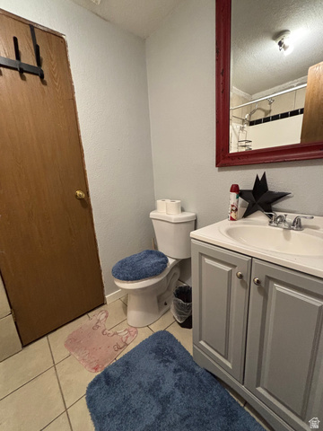 615 North 250 W Road Hinckley, UT 84635 - Photo 12 of 16 Bathroom featuring a single vanity with a white countertop, a white porcelain toilet, and light-colored tile flooring