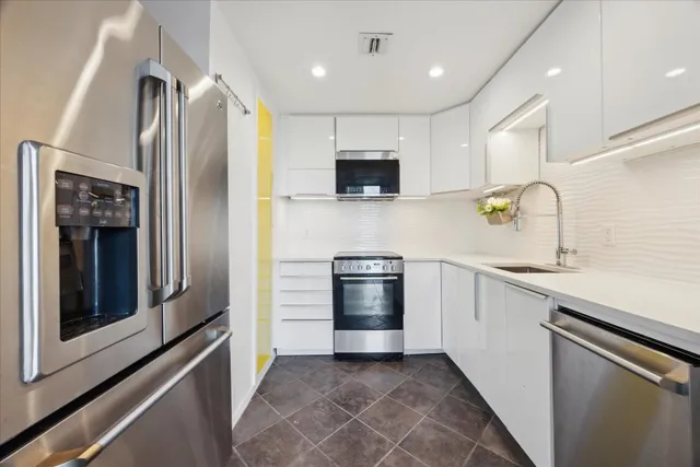 a kitchen with stainless steel appliances and white cabinets