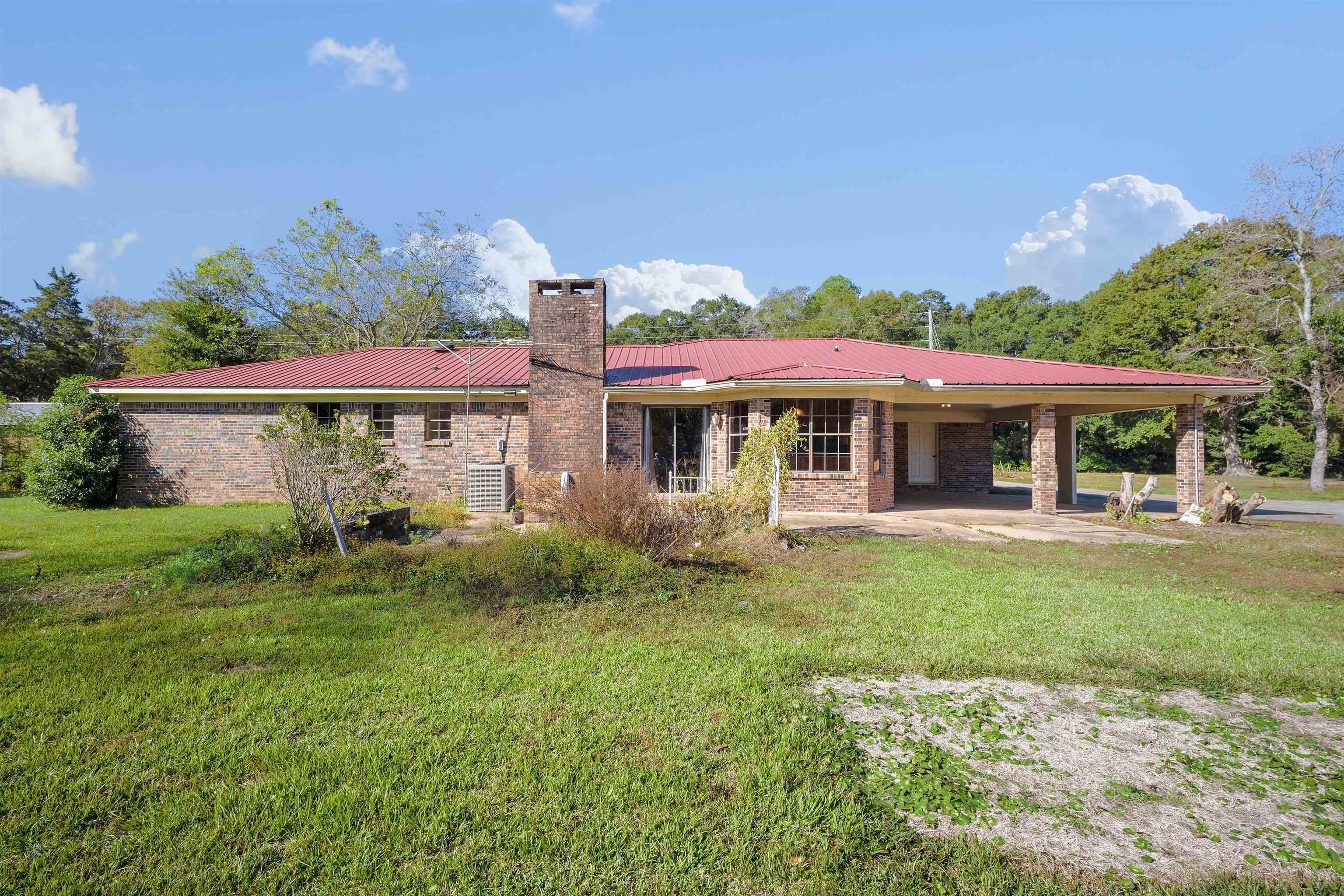 10285 Argyle Road Irvington, AL 36544 - Photo 25 of 28 Back of property with a patio area, a chimney, a metal roof, an attached carport, and brick siding