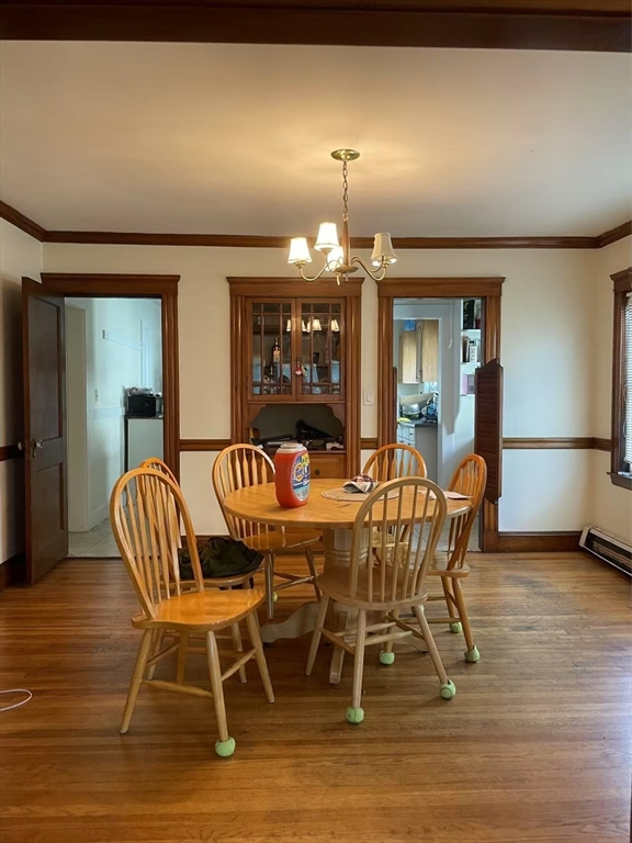 a dining room with furniture a chandelier and wooden floor