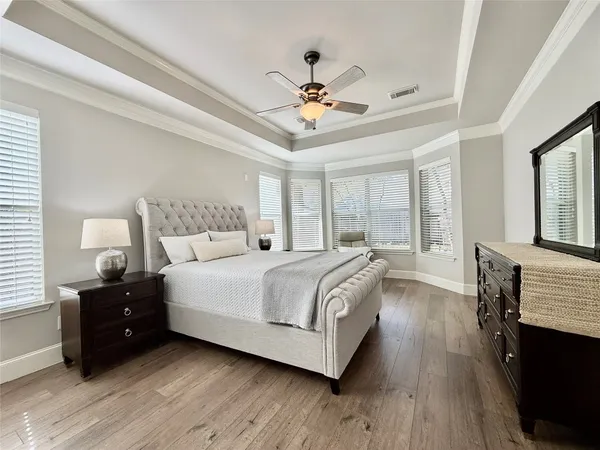 a bedroom with a bed and wooden floor