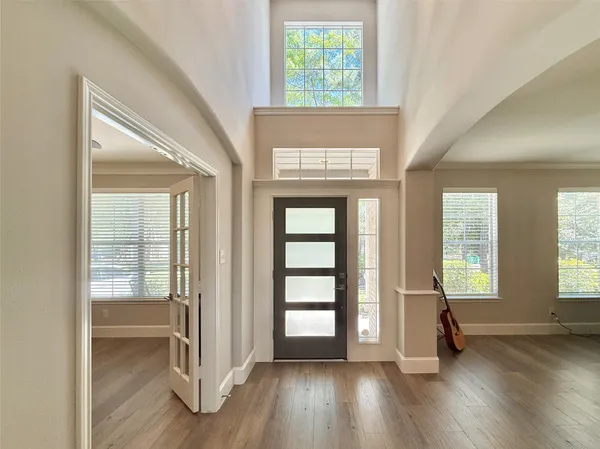 an empty room with wooden floor and windows