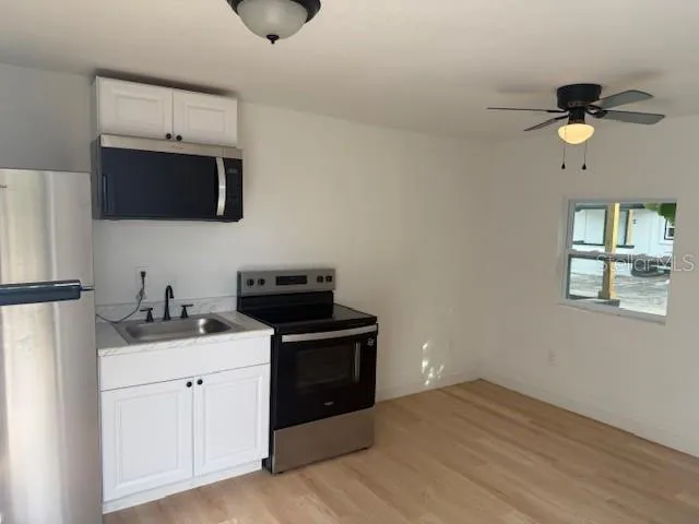 a kitchen with a sink stainless steel appliances and cabinets