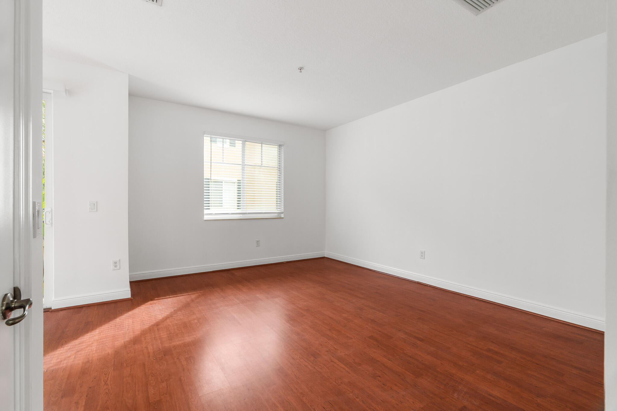 3830 Northwest 5th Terrace Boca Raton, FL 33431 - Photo 13 of 34 an empty room with wooden floor and windows