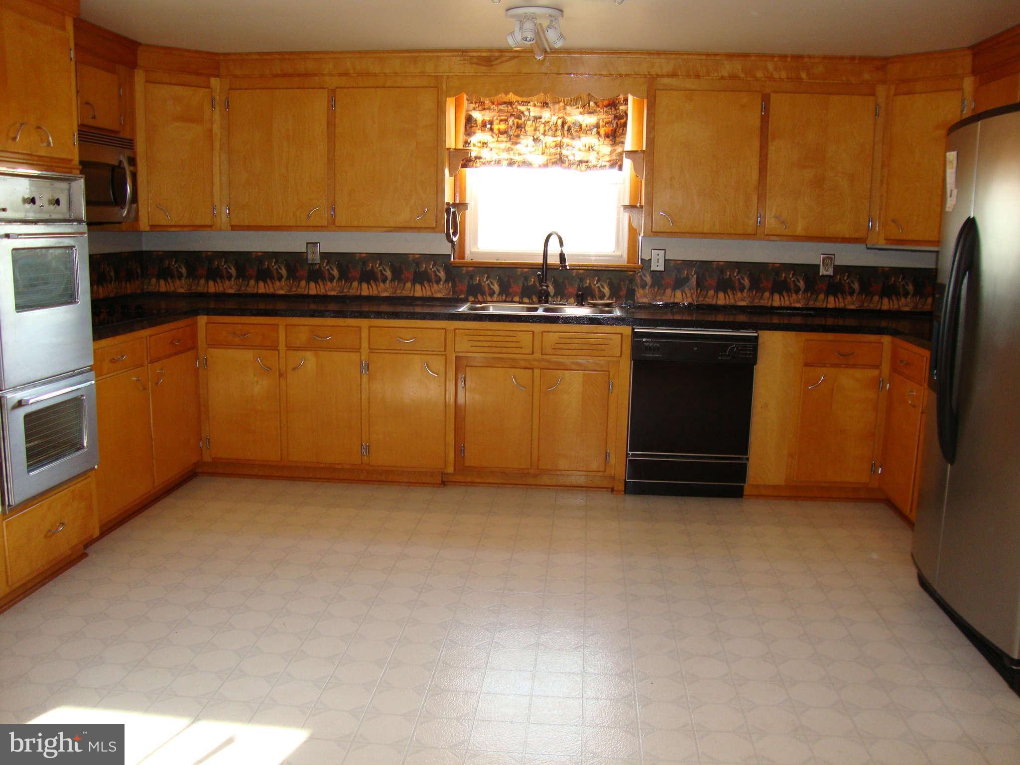 9709 Appolds Road Rocky Ridge, MD 21778 - Photo 5 of 13 a kitchen with granite countertop a stove a sink and a microwave