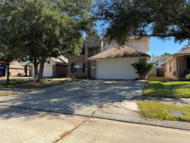 a view of a white house with a large tree with yard