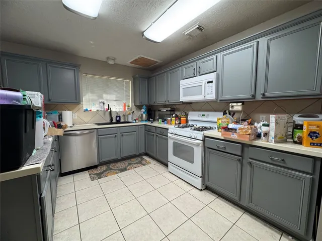 a kitchen with cabinets a sink and white stainless steel appliances
