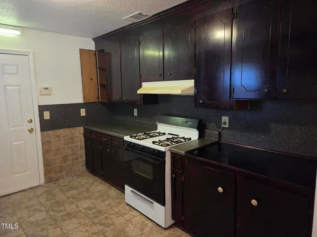 a stove top oven sitting inside of a kitchen