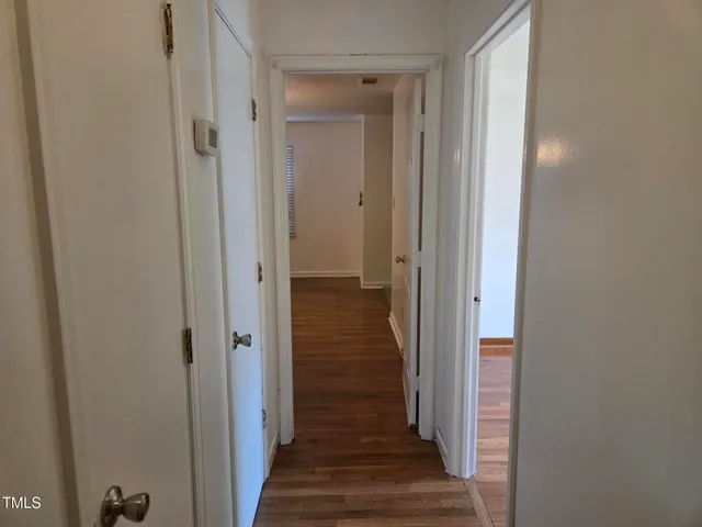 a view of a hallway with wooden floor