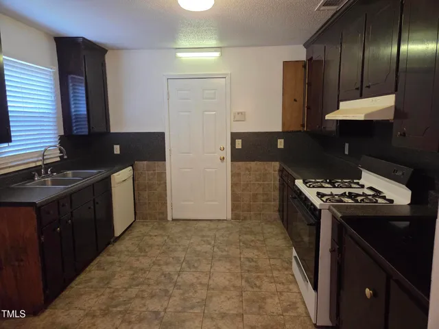 a kitchen with a refrigerator and a sink