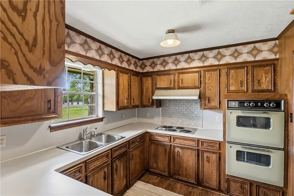 a kitchen with stainless steel appliances granite countertop a sink a stove and cabinets