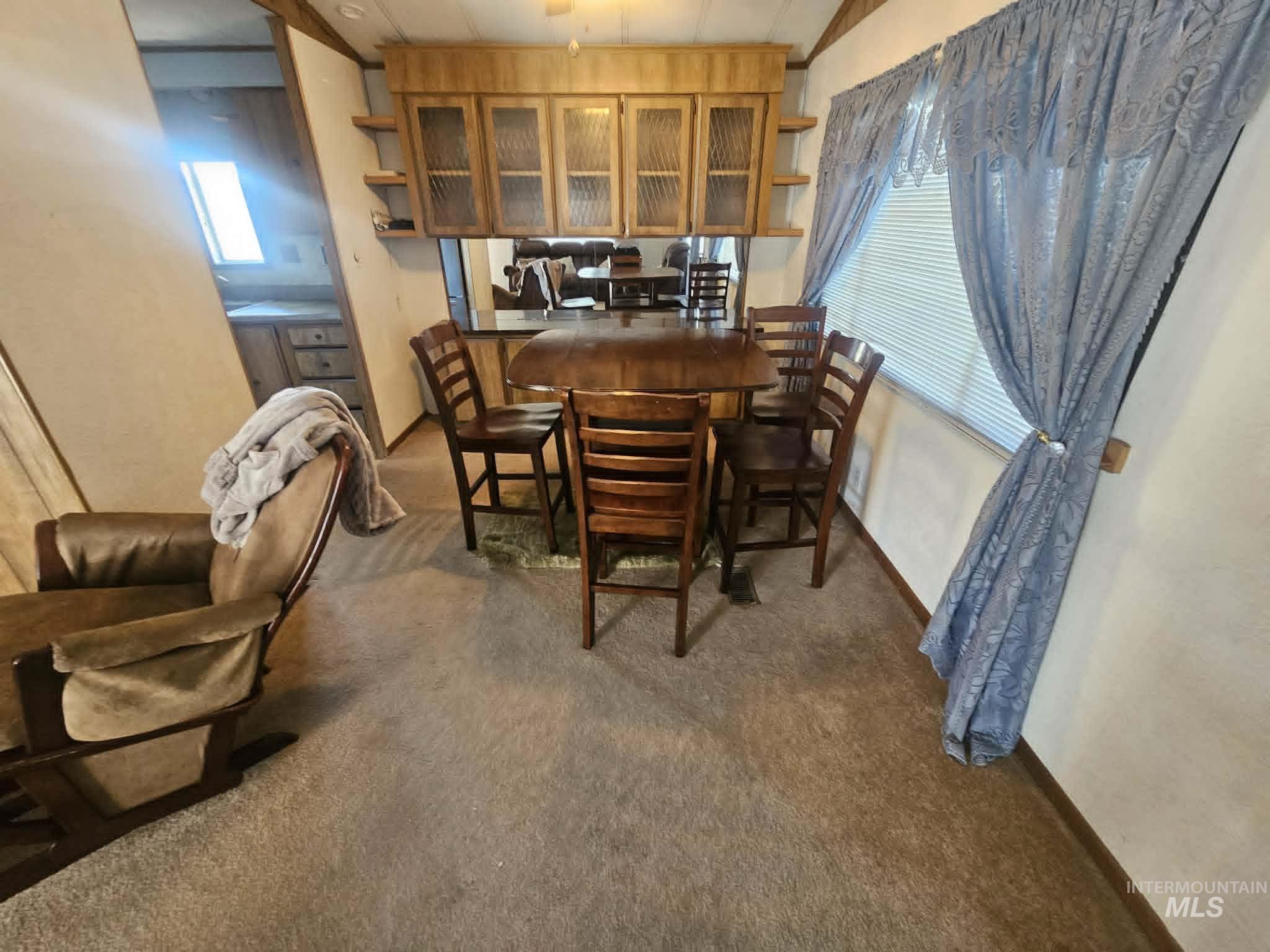 461 Greenleaf Street Boise, ID 83713 - Photo 11 of 19 Dining area featuring built-in wood cabinetry with glass-front doors, open shelving, and a large window with blinds