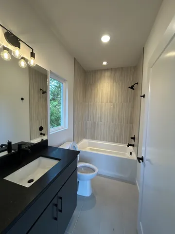 a bathroom with a bathtub a sink and a large mirror