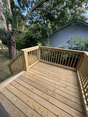 a view of balcony with wooden floor and fence