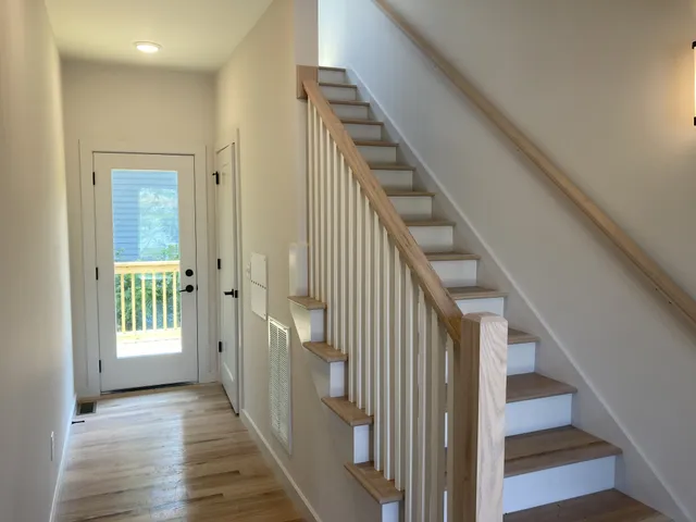 a view of a hallway with wooden floor and entryway