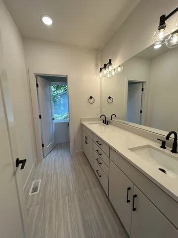 a spacious bathroom with double vanity a sink and a mirror