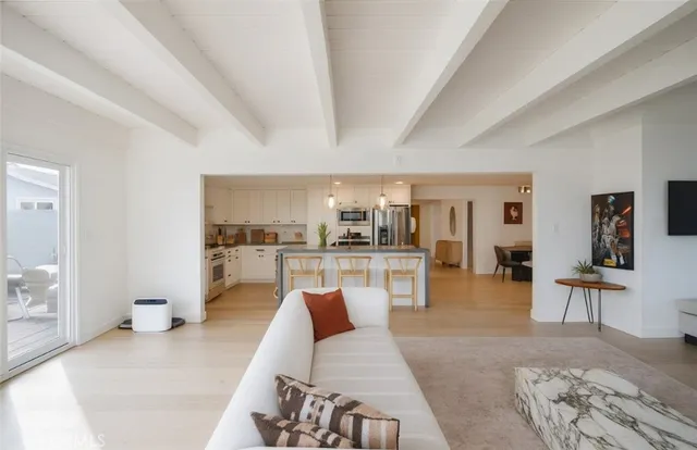 a living room with furniture and view of kitchen