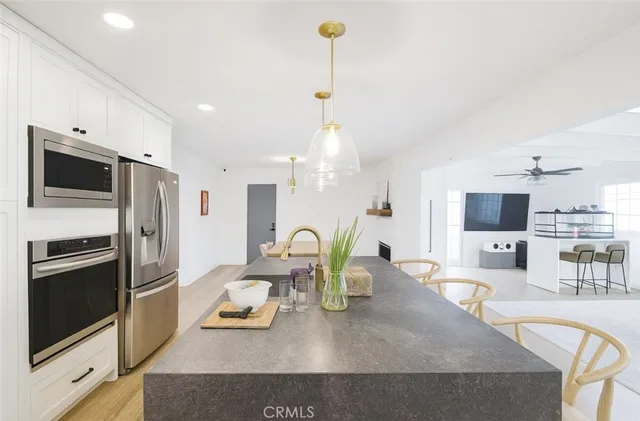 a kitchen with stainless steel appliances granite countertop a sink refrigerator and microwave