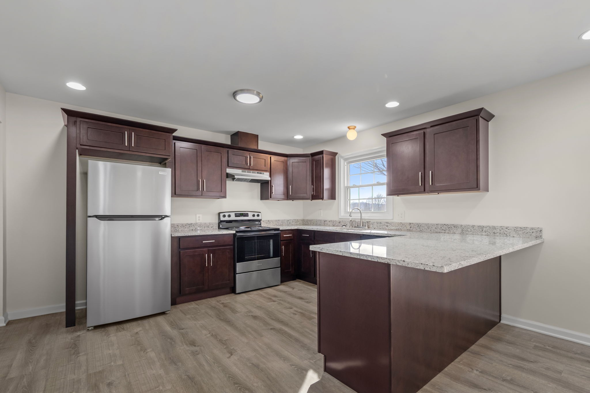 456 Whites Gap Road Huntland, TN 37345 - Photo 12 of 35 a kitchen with stainless steel appliances granite countertop a stove a refrigerator a sink a oven and a microwave oven with wooden floor
