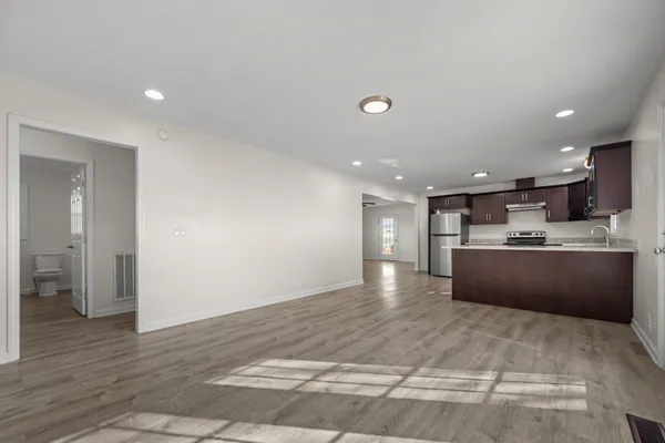 a view of kitchen with refrigerator sink and wooden floor