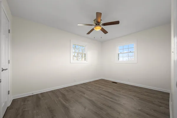 a view of a room with wooden floor and window