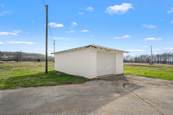 a view of a house with a yard and a basket ball court