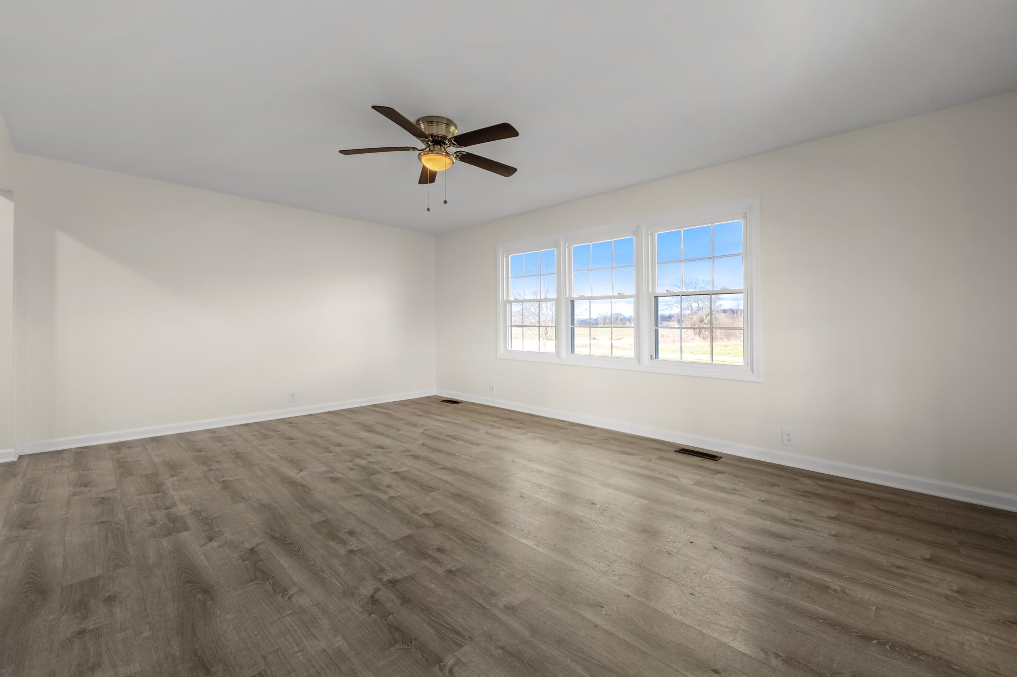 456 Whites Gap Road Huntland, TN 37345 - Photo 4 of 35 a view of empty room with wooden floor and fan