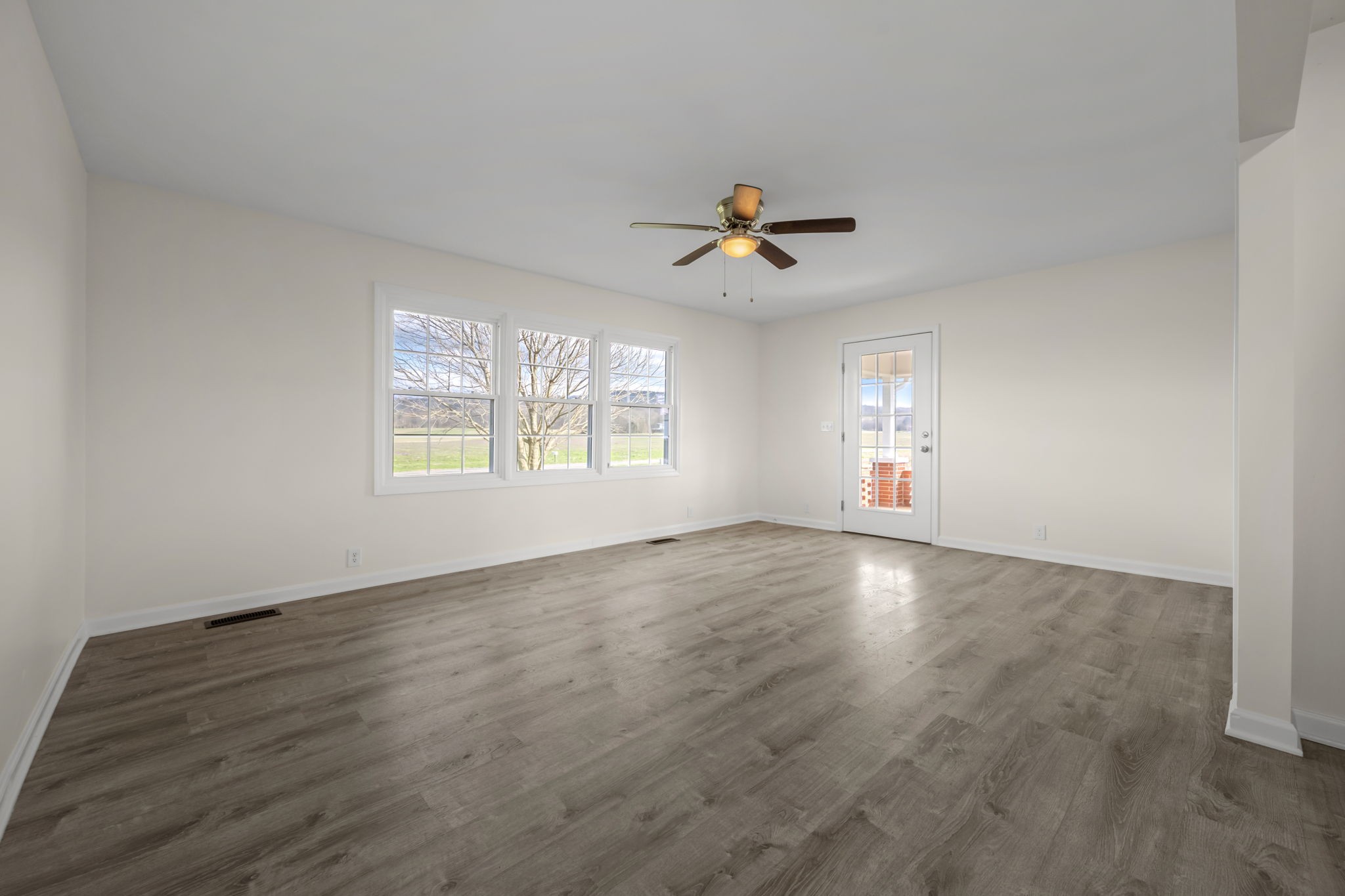 456 Whites Gap Road Huntland, TN 37345 - Photo 5 of 35 a view of an empty room with a window and wooden floor