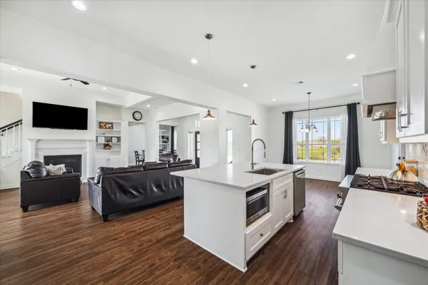 a large kitchen with stainless steel appliances granite countertop a lot of counter space and wooden floor