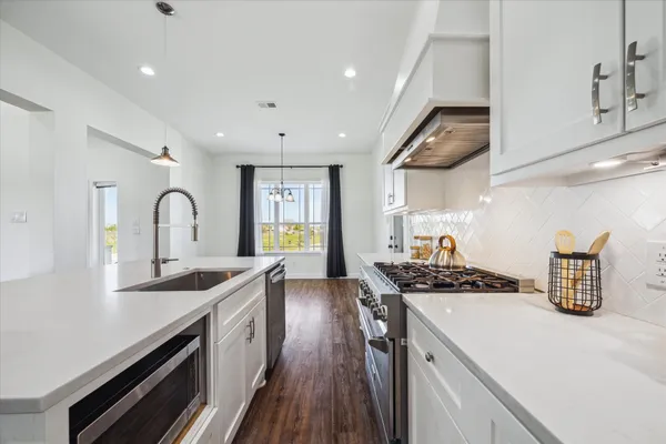 a kitchen with kitchen island stainless steel appliances a sink stove and cabinets