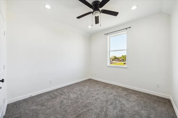 an empty room with a window and ceiling fan