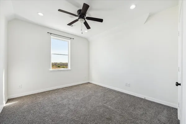 an empty room with a window and a ceiling fan